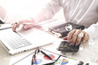 © everythingpossible - businessman hand working with finances about cost and calculate  and latop with mobile phone on withe desk in modern office