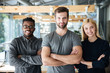 © Drobot Dean - Smiling young colleagues standing with arms crossed