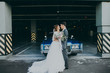 Just married couple in the blue retro car on their wedding