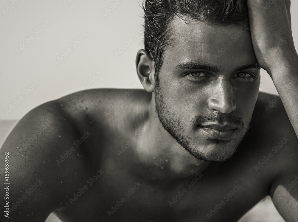 Sexy closeup portrait of handsome topless male model with beautiful eyes on the beach. Black and White. - obrazy, fototapety, plakaty 