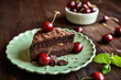 Chocolate cake filled with cocoa whipped cream and decorated with chocolate shavings and cherry