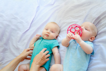 indoor portrait of young happy smiling mother with twin babies at home