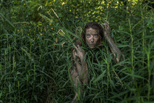 Muddy Amazon Brown-haired Girl Hiding Behind A Bush In The Woods
