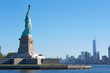 Statue of Liberty island and New York city skyline in a sunny day, blue sky