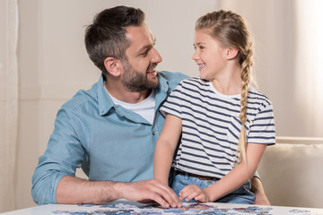 Wall Mural - man playing puzzle with daughter at home