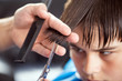 © DariuszO - Dark haired boy at hairdresser while hairdressing by hairdresser
