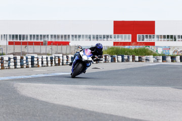 Motorcycle racer on sportbike leaning into a fast corner on track