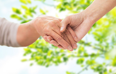 Wall Mural - close up of senior and young woman holding hands