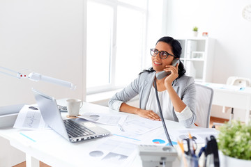 Wall Mural - businesswoman calling on desk phone at office