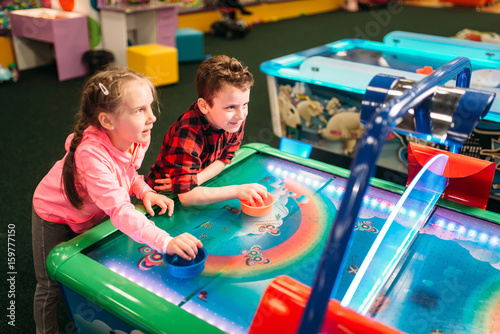Fotomural Little kids plays air hockey, entertainment center