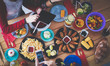 © lenets_tan - Top view of group of people having dinner together while sitting at wooden table. Food on the table. People eat fast food.