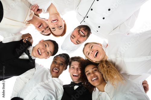 Fotomural Smiling Restaurant Staff Standing Against White Background