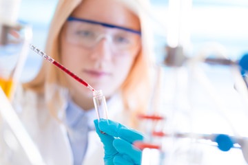 Wall Mural - Female laboratory assistant with chemical experiment in scientific laboratory