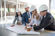 © LIGHTFIELD STUDIOS - group of contractors in formal wear working with blueprints at construction area
