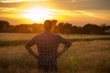 © Budimir Jevtic - Rear view of farmer in field at sunset