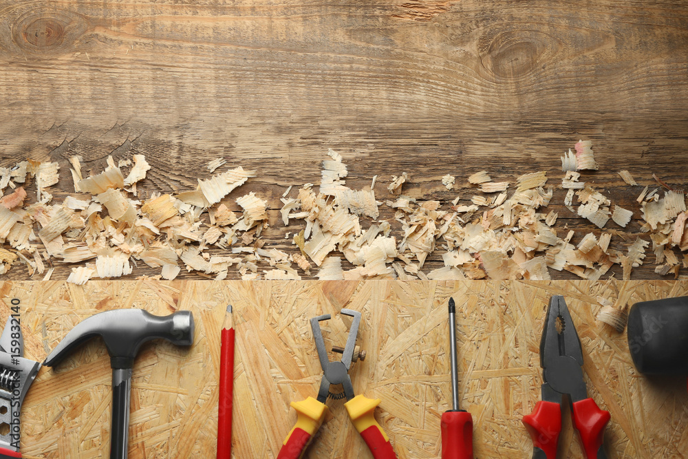 Set of carpenter's tools and saw dust on wooden table