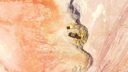 Wall Mural - Aerial view of a excavator loading a truck in open cast mine or on construction site. Heavy industry from above. Industrial background from drone. 