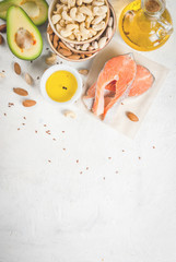 Wall Mural - Healthy food. Products with healthy fats. Omega 3, omega 6. Ingredients and products: trout (salmon), flaxseed oil, avocado, almonds, cashews, pistachios. On a white stone table. Copy space top view