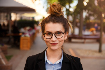 young caucasian businesswoman in glasses smiling pursed lips.