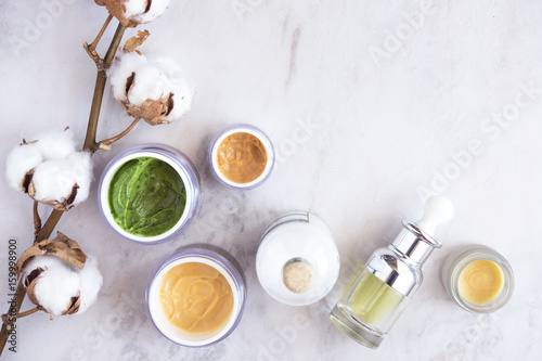Fotografía Natural skincare cosmetic products on white marble table from above