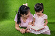Leinwandbild Motiv Asian Chinese mother and daughter reading the book