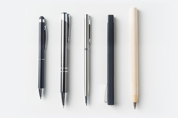 Top view of collection of pens on white background desk for mockup