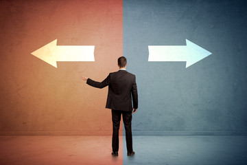 Wall Mural - Salesman standing in front of two arrows on blue and red background concept