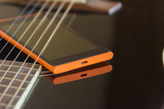 mobile phone on black acoustic  guitar, old and new connection concept
