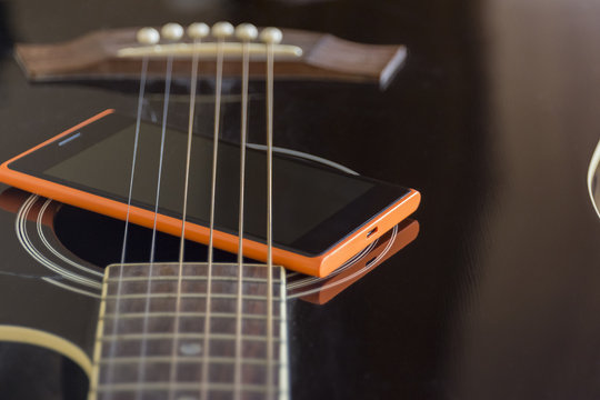 mobile phone on black acoustic  guitar, old and new connection concept