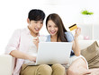 © Tom Wang - Happy young couple sitting on sofa  with laptop