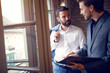 © luckybusiness - Two young businessmen talking in office