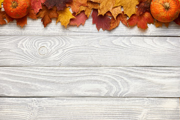 Poster - Autumn leaves and pumpkins over old wooden background