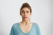 © WHstudio Leushin N - Omg! Cropped shot of frightened terrified woman with blue popped out eyes frowning her lips with panic. Moving stressful woman in blue shirt realizing horrified news looking with anxiety into camera