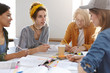 © WHstudio Leushin N - University, college, teamwork concept. Thrree college females and one bearded guy sitting at desk with books doing their research work discussing their plans writing notes. Group of students working