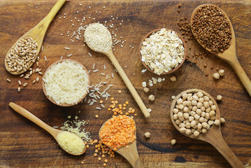 Wall Mural - Different types of cereals in wooden spoons - buckwheat, chickpeas, rice, quinoa, lentils