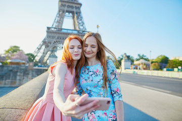 Wall Mural - Two friends taking selfie near Eiffel tower in Paris, France