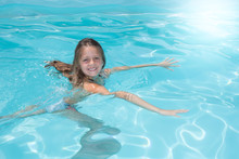 Little Girl Swimming In Pool In Summer Vacation