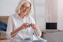 Cheerful Elderly Woman Holding Knitting Needles