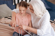 Positive delighted woman knitting with her granddaughter
