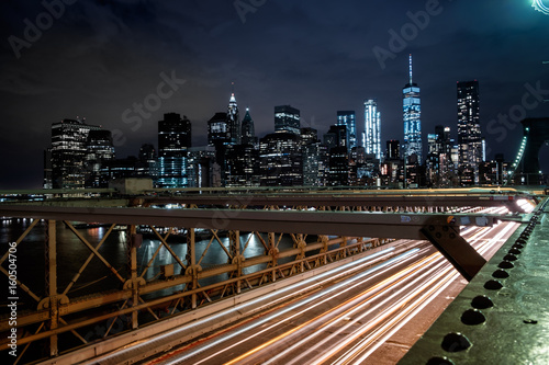 View from the Brooklyn Bridge at night with the One World Trade Center and traff Poster