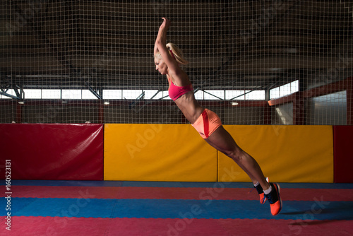 Plakat Fitness kobieta wykonywania skok w dal w siłowni