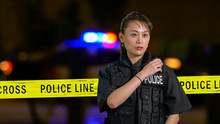 Asian American Policewoman Using Police Radio