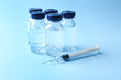 © Africa Studio - Vaccine in vials with syringe on color background