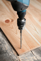 Canvas Print - Drilling hole in wooden board at carpenter's workshop