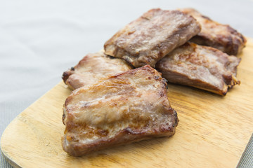 grilled pork rib on wooden cutting board, close up