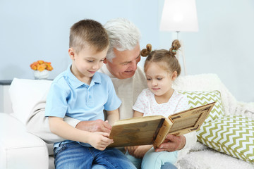 Poster - Grandfather looking at photo album with his grandchildren