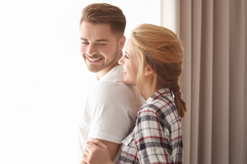 Poster - Happy young couple near window at home