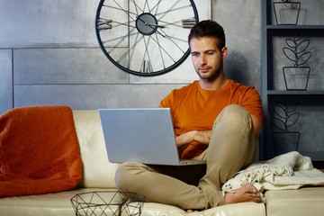 Young man using laptop computer at home