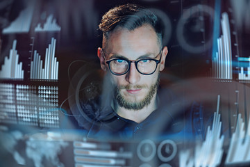 Wall Mural - Concept of digital diagram,graph interfaces,virtual screen,connections icon.Portrait of young businessman working modern office.Man using contemporary laptop at night,blurred background.Horizontal.