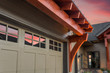 Beautiful Luxury Home Exterior Detail at Sunset: Garage Door with Partial View of Front Entrance and Colorful Sunset Sky